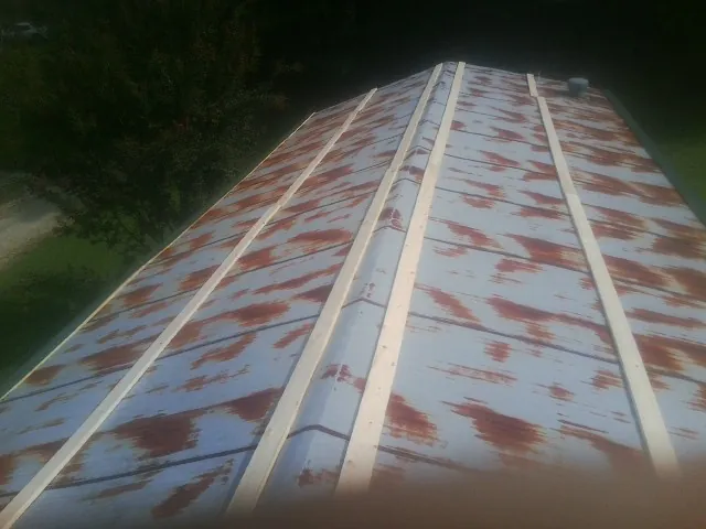 Rusted metal roof panels with new wood purlins before replacement — Storm Damage Roof Repair in Bastrop by Roofing Brothers